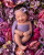 4. Baby Sarah tersenyum manis dikelilingi bunga